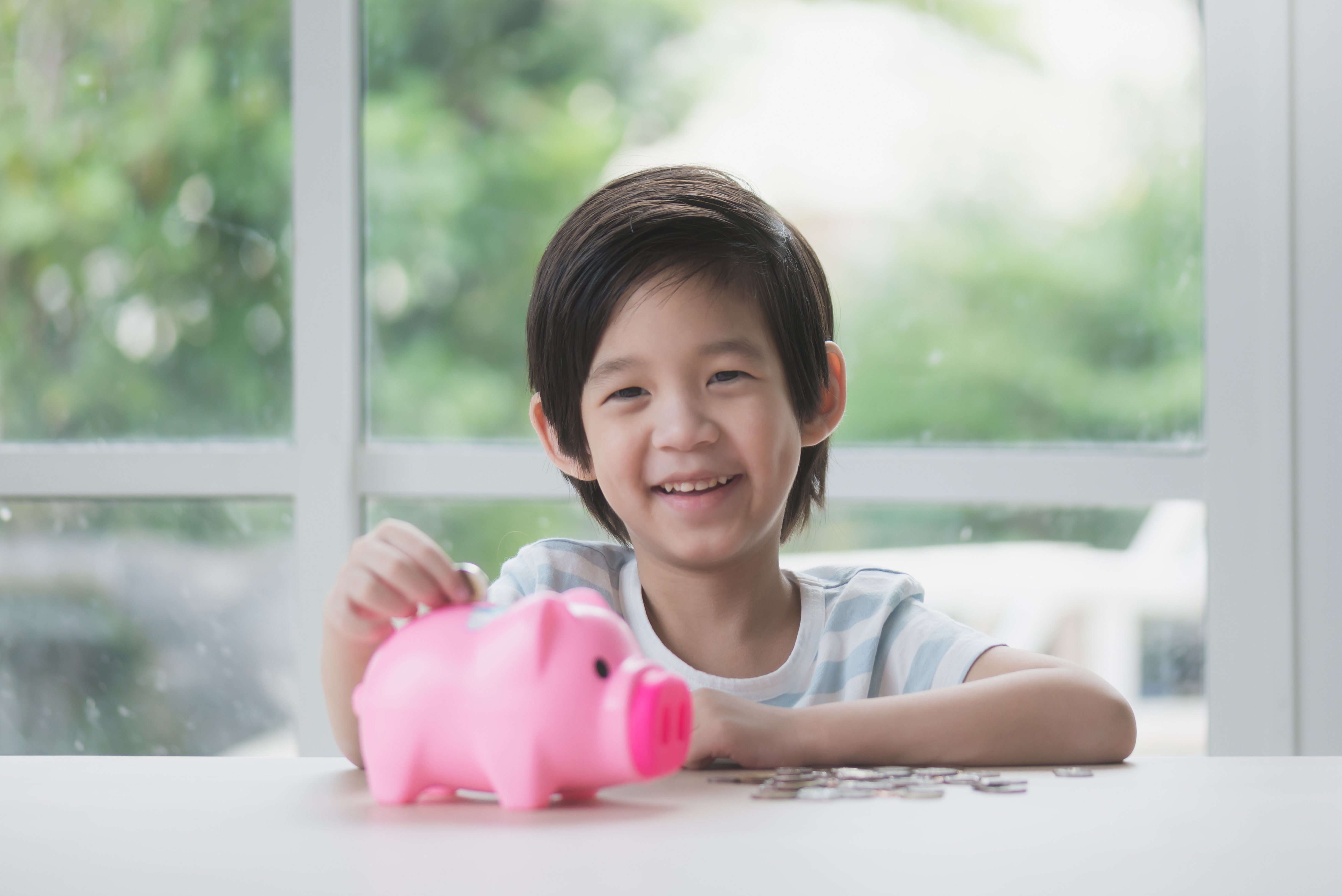 cute-asian-child-putting-a-coin-into-a-piggy-bank-2026-01-11-10-32-59-utc